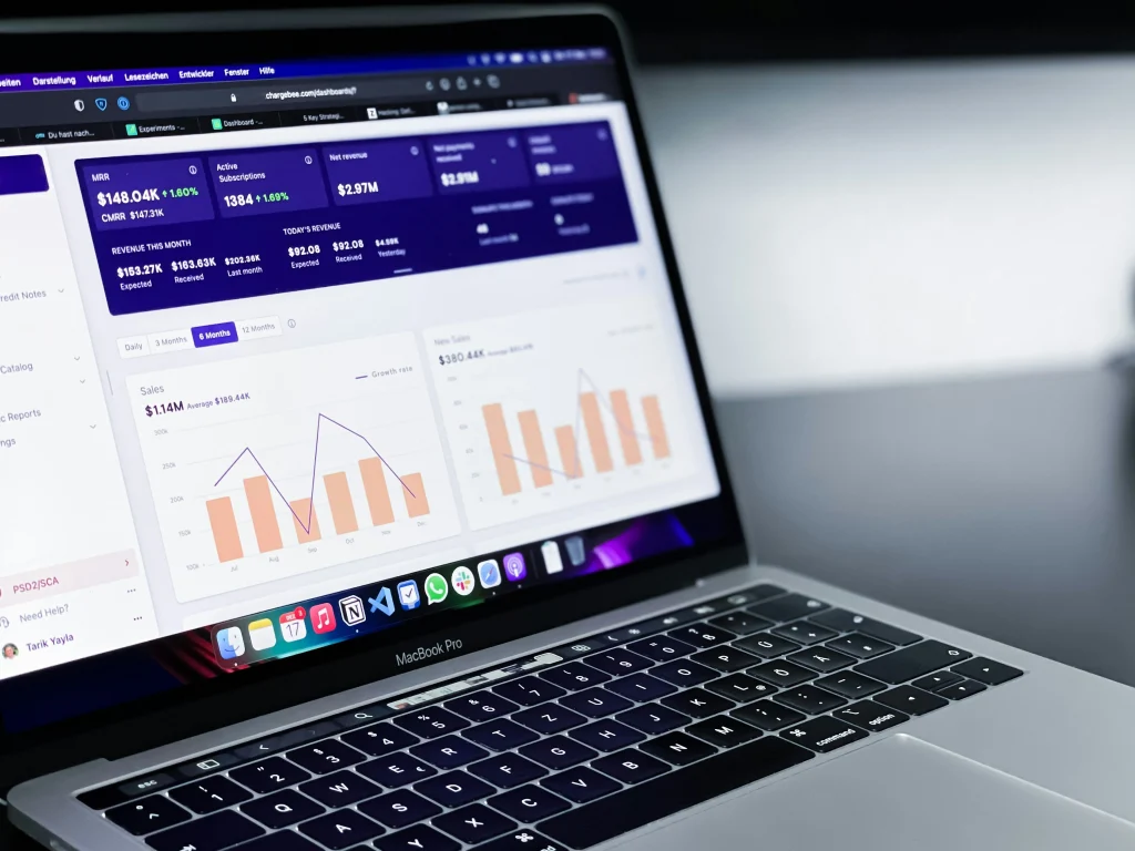 Laptop displaying business analytics dashboard and charts.