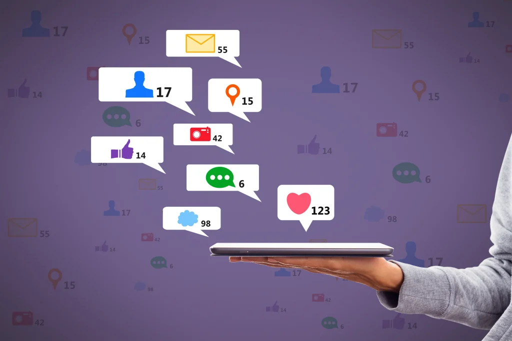 Hand holding tablet with social media icons.