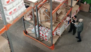 Warehouse workers inspecting inventory on shelves.