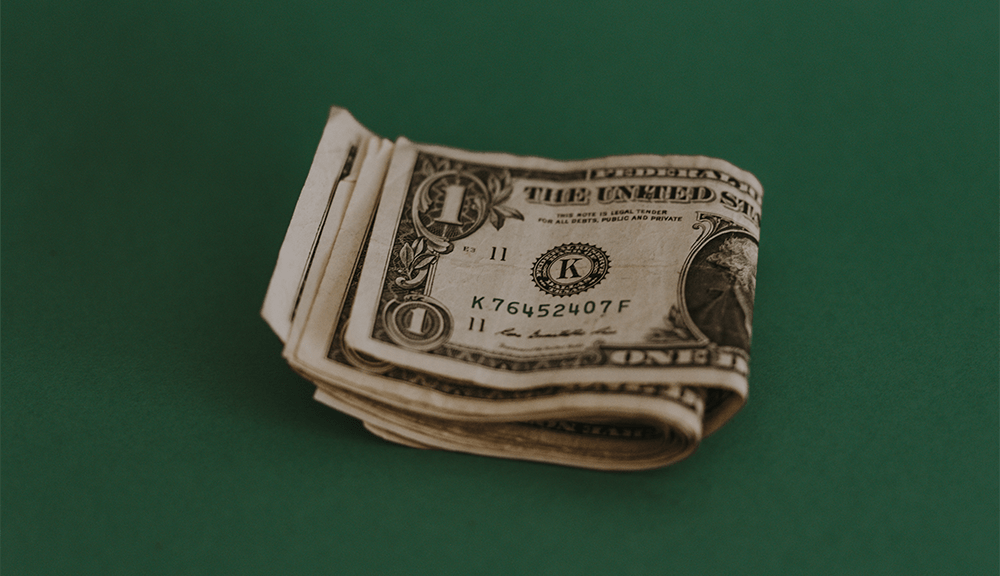 Stack of one-dollar bills on green background