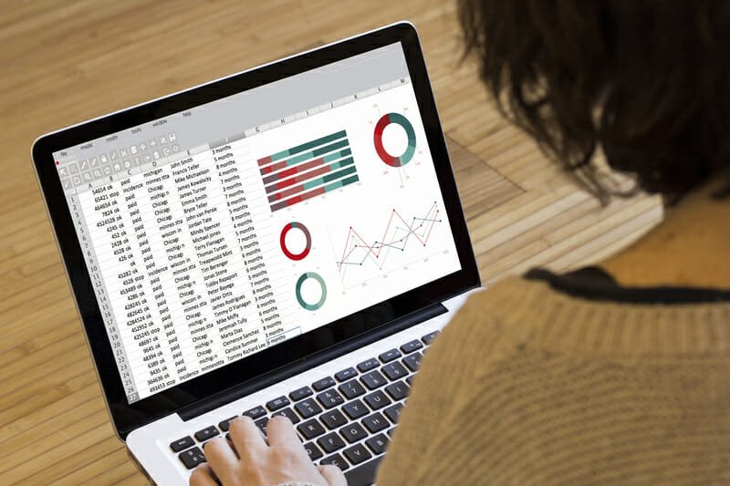 Person analyzing graphs on laptop screen.