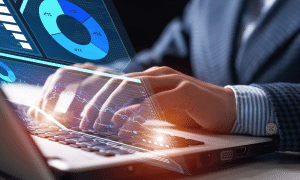 Person typing with business analytics on computer screen.