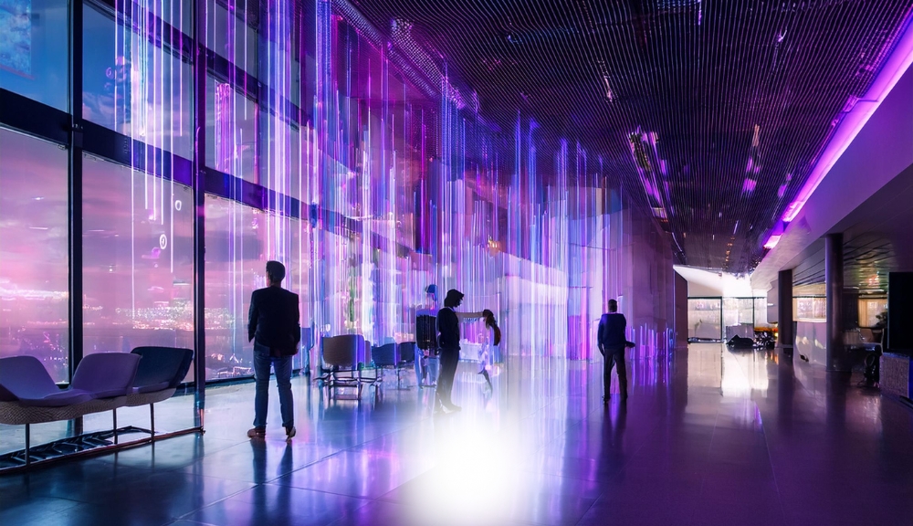 People in futuristic room with neon lights.