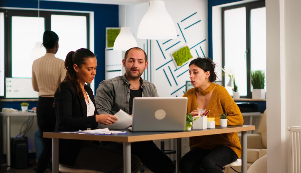 two women and a men sitting and analyzing marketing campaign performance results