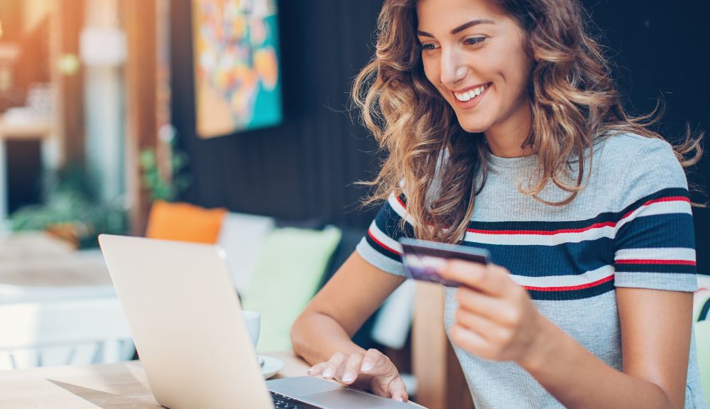 Woman shopping online with laptop and credit card.
