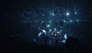 Abstract light show with geometric shapes on stage.