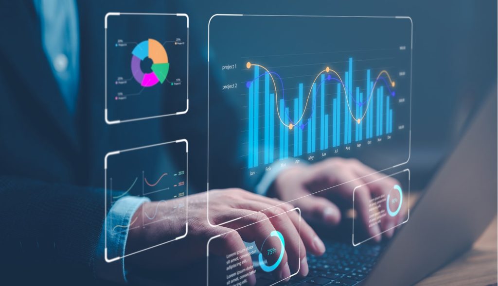 Digital graphs displayed over laptop with hands typing.