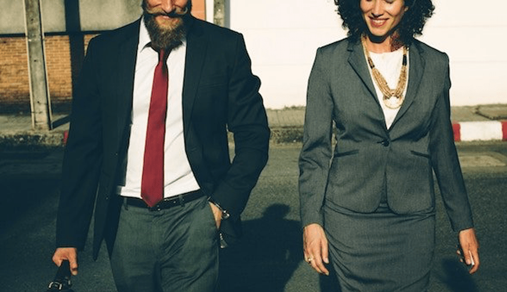 Business professionals walking confidently together outdoors.