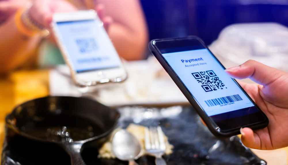 Phones scanning QR code for payment.