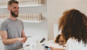 Customer paying at checkout with smartphone.