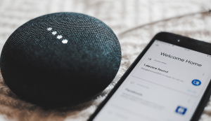 Smart speaker next to smartphone setup screen