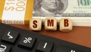 Calculator, cash, SMB cubes on table.