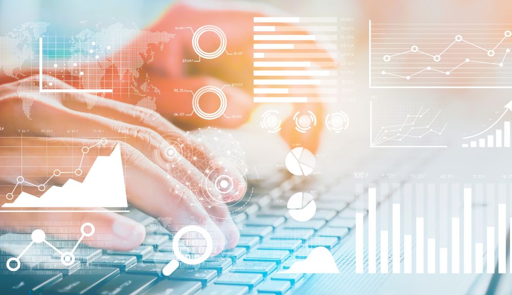 Hands typing on keyboard with data graphics overlay.