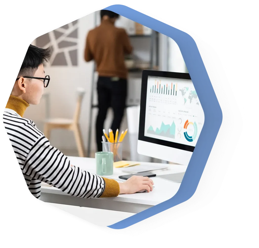 Persona analizando datos en la pantalla del ordenador en la oficina.