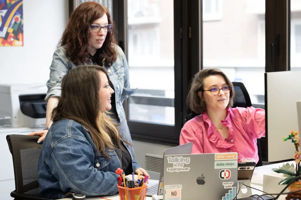 Three women collaborating in an office.